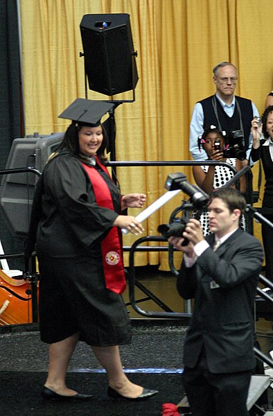On stage with diploma in hand.